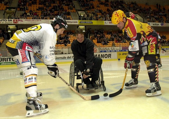 2002 wirft Pat Schafhauser den Puck zum Bully zwischen Luganos Corey Millen und Langnaus Todd Elik ein.