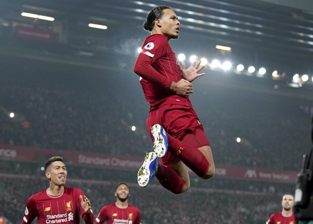Liverpool's Virgil van Dijk jumps to celebrate scoring his side's first goal during the English Premier League soccer match between Liverpool and Manchester United at Anfield Stadium in Live ...