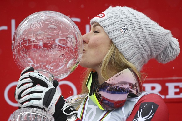 United States&#039;s Mikaela Shiffrin kisses the women&#039;s World Cup overall trophy, at the alpine ski World Cup finals in Are, Sweden, Sunday, March 18, 2018. (AP Photo/Marco Trovati)