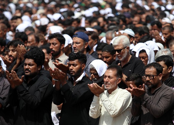 epa09904160 Pakistani Shiite Muslims offer prayer during a procession to mark the death anniversary of Imam Ali, the son-in-law of Prophet Mohammad during the holy month of Ramadan, in Karachi, Pakist ...