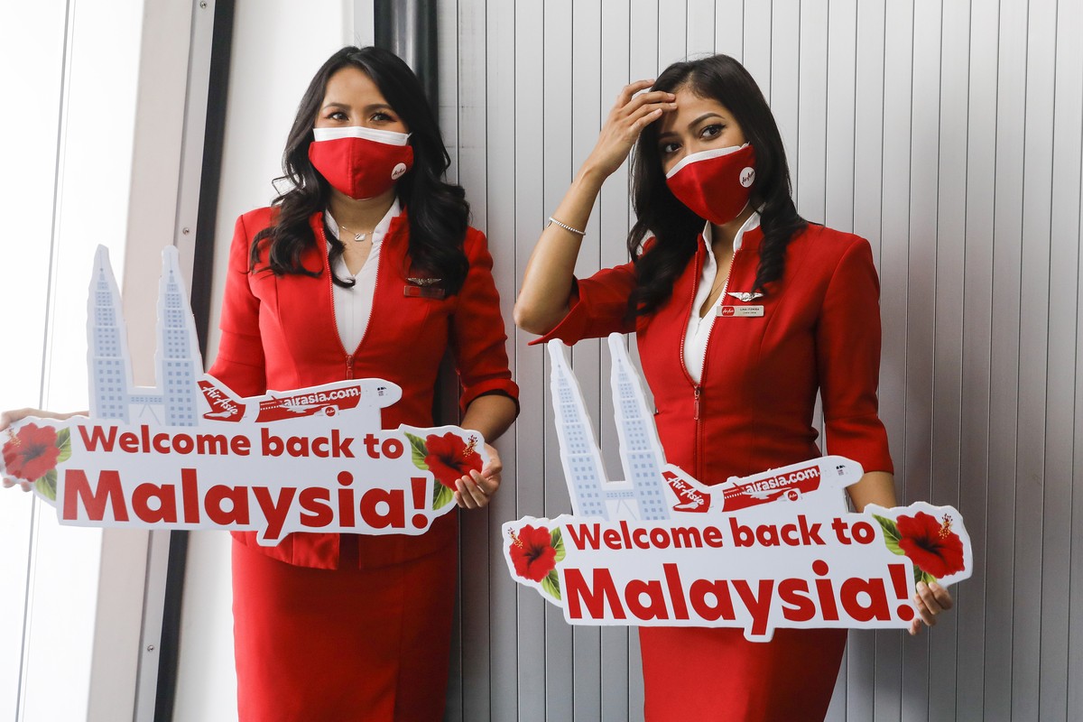 epa09863125 Air Asia flight attendants wait for passenger from AirAsia A320 Airbus aircraft from Jakarta after it landed in Kuala Lumpur International Airport 2 (KLIA 2), Sepang, Malaysia, 01 April 20 ...