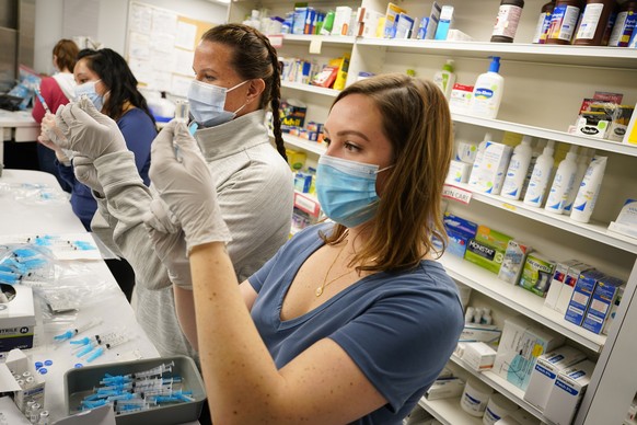 FILE�?? In this March 6, 2021 file photo, from front, registered nurses Megan McLaughlin and Amy Wells join pharmacist Claudia Corona-Guevara in drawing shots of Johnson &amp; Johnson COVID-19 vaccine ...