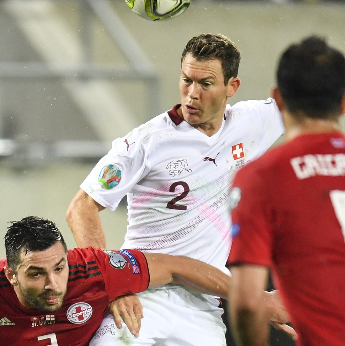 Switzerland's defender Stephan Lichtsteiner, center, fights for the ball with Georgia's Davit Khocholava, left, during the UEFA Euro 2020 qualifying Group D soccer match between Switzerland  ...