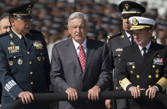 FILE - Mexican President Andres Manuel Lopez Obrador, flanked by Defense Secretary Gen. Luis Crescencio Sandoval, left, and Marine Secretary Jose Rafael Ojeda, surveys National Guard troops as the new ...