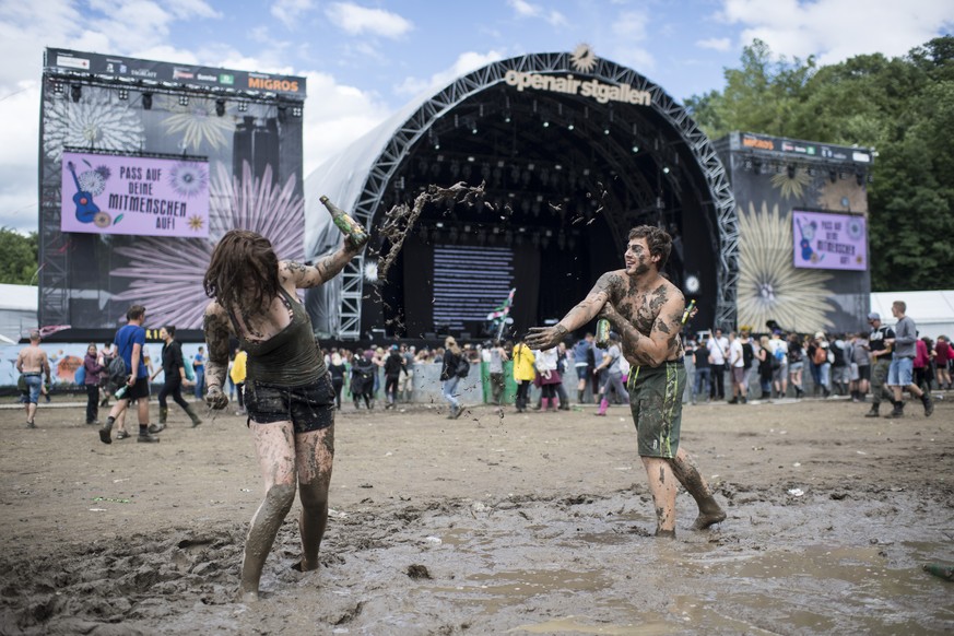 Visitors play in a puddle during the music festival Openair St. Gallen, on Saturday, July 1, 2017. The festival will take place until Sunday, July 2, 2017. (KEYSTONE/Ennio Leanza)