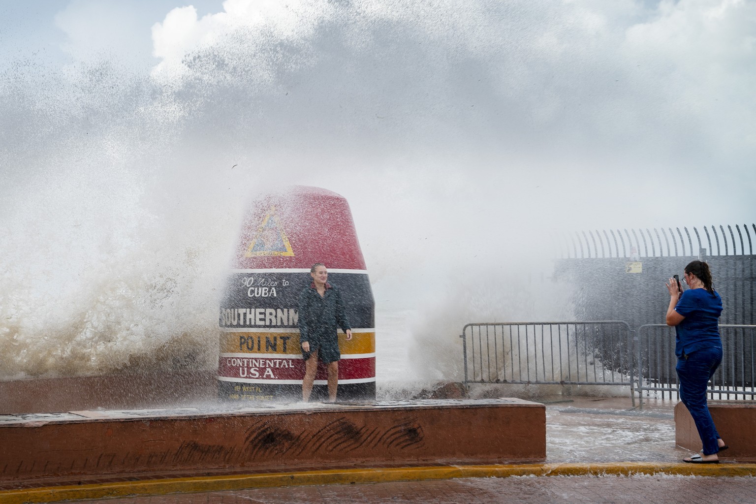 Visitors to the Southernmost Point buoy brave the waves made stronger from Hurricane Idalia on Tuesday, Aug. 29, 2023, in Key West, Fla. Feeding on some of the hottest water on the planet, Hurricane I ...
