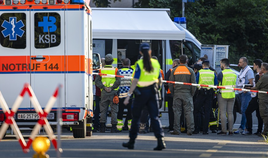 Einsatzkraefte der Kantonspolizei Aargau, der Saenitaet und des Zivilschutzes nach einem Brand in einem Mehrfamilienhaus in Spreitenbach, am Montag, 8. Juli 2024. Gemaess Polizeiangaben wurden beim Br ...