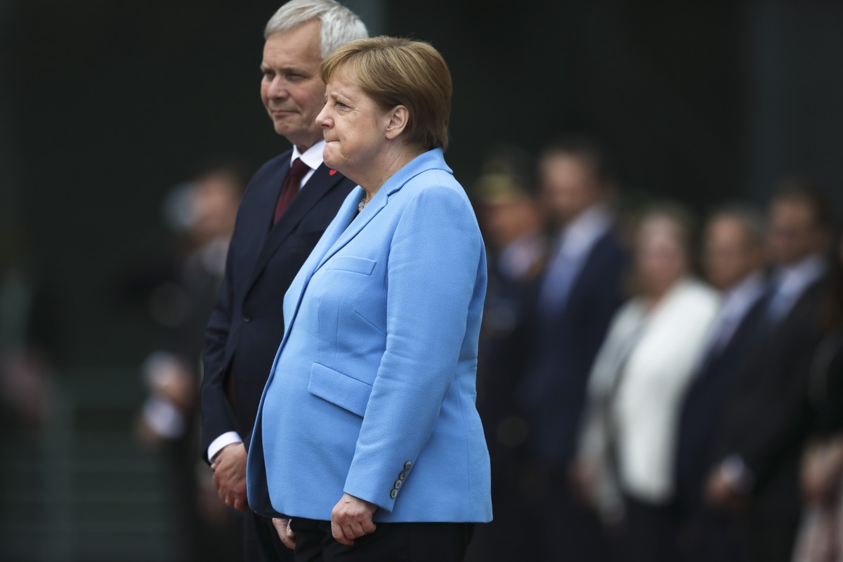 German Chancellor Angela Merkel, right, and Prime Minister of Finland Antti Rinne listen to the national anthems at the chancellery in Berlin, Germany, Wednesday, July 10, 2019. Merkel's body sho ...