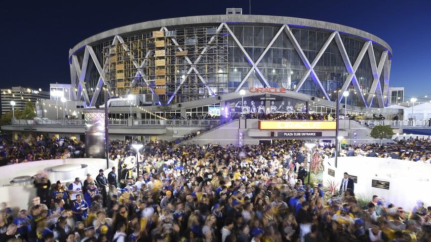 FILE - In this June 8, 2018 long exposure file photo, Golden State Warriors fans celebrate outside Oracle Arena in Oakland, Calif. The Warriors defeated the Cleveland Cavaliers 108-85 in Game 4 of the ...
