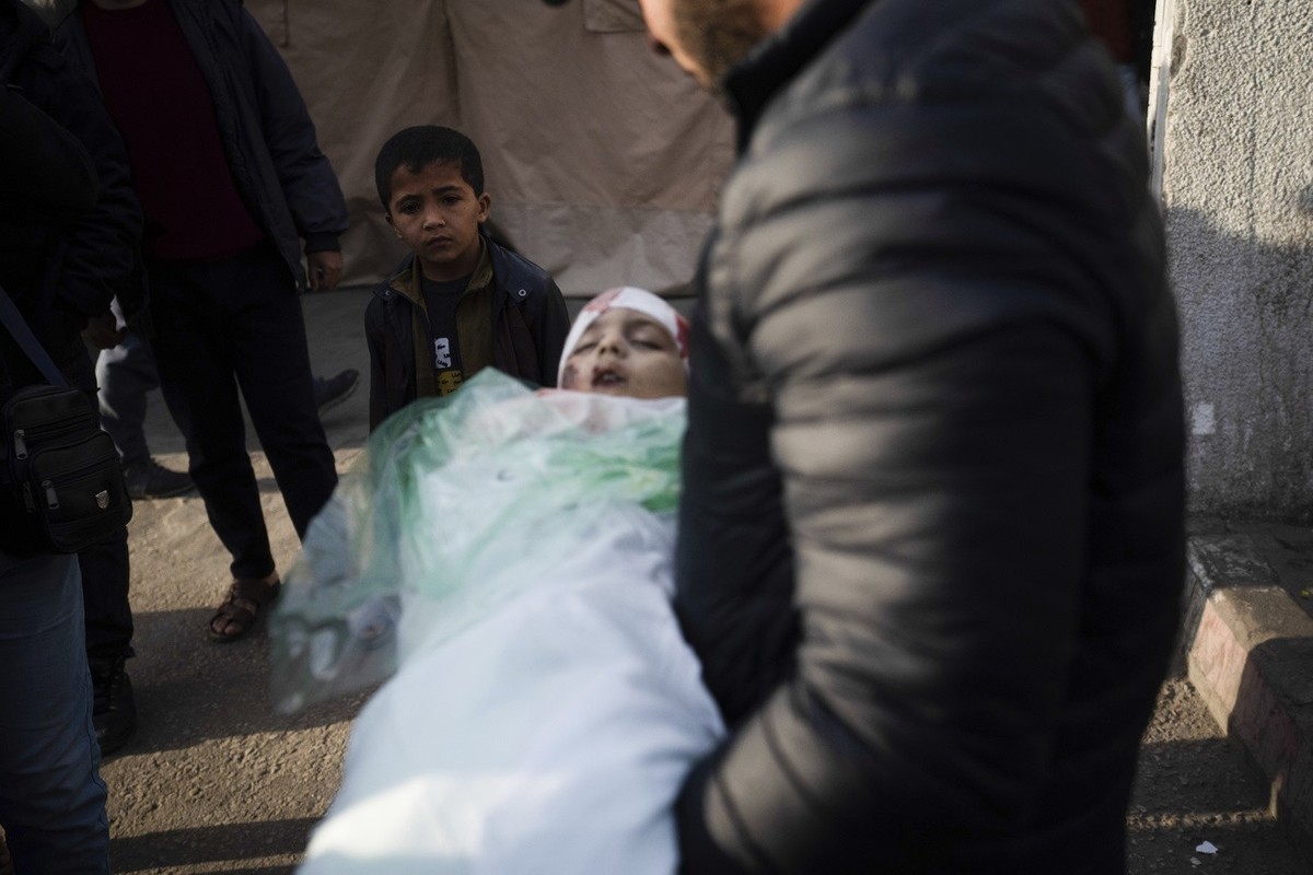 A relative of Masa Shouman holds her body during her funeral in Rafah, southern Gaza, Wednesday, Jan. 17, 2024. Shouman was killed in an Israeli bombardment of the Gaza Strip. (AP Photo/Fatima Shbair)
