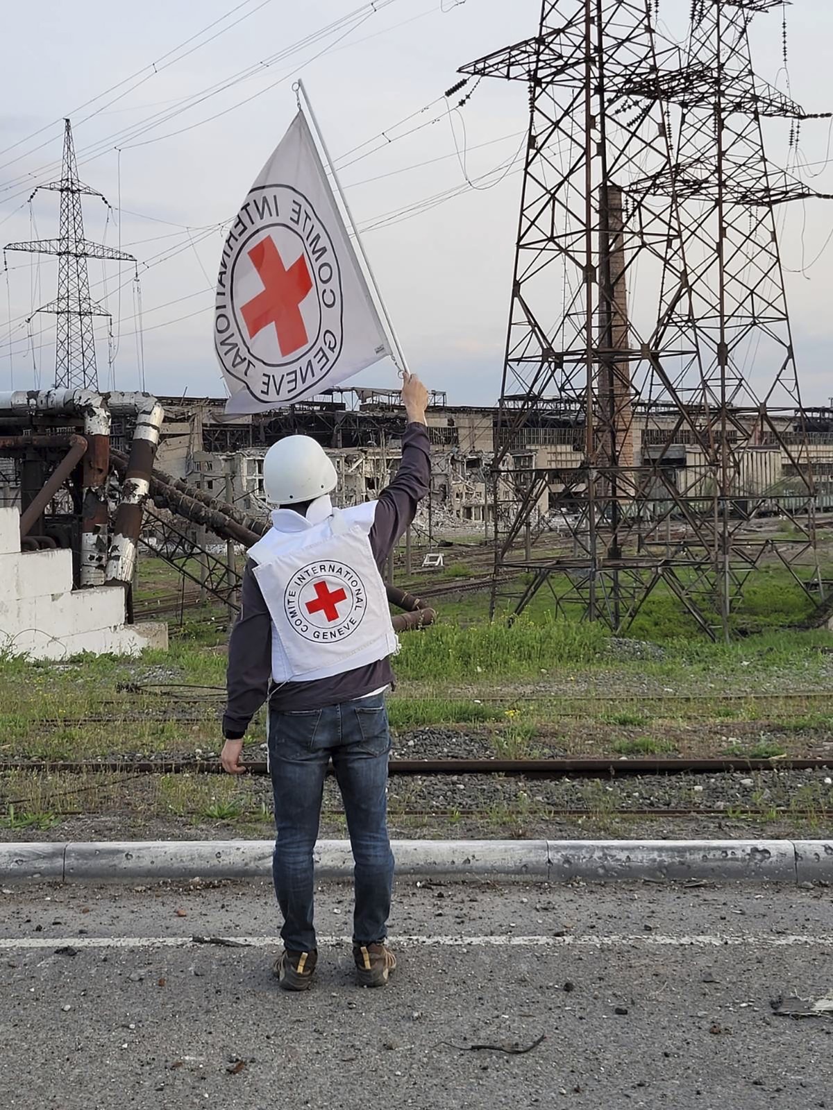 In this image provided by the International Committee of the Red Cross, a Red Cross official waves a white flag while approaching the Azovstal steelworks in Mariupol, Ukraine, Sunday, May 1, 2022. A l ...