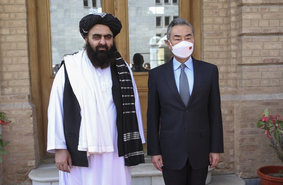 In this photo released by Xinhua News Agency, Chinese Foreign Minister Wang Yi, right, poses for photos with Amir Khan Muttaqi, acting foreign minister of the Afghan Taliban&#039;s caretaker governmen ...