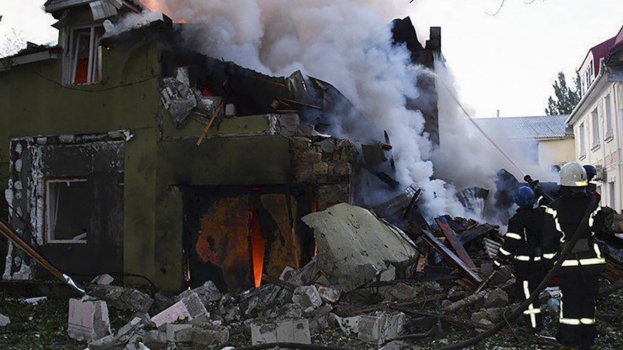 epa10066461 A handout photo released by the press service of the State Emergency Service of Ukraine shows firefighters putting out a fire at a residential building after shelling hit the village of Sh ...