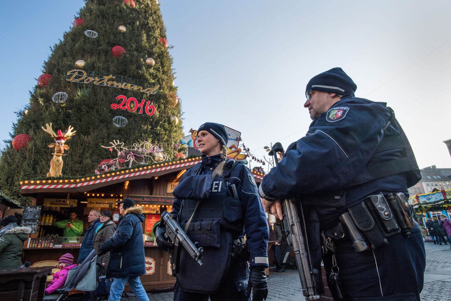 epa05683252 Police officers patrol the Christmas market in Dortmund, Germany, 20 December 2016. Police are stepping up security measures at markets across Germany after 12 people were killed and at le ...