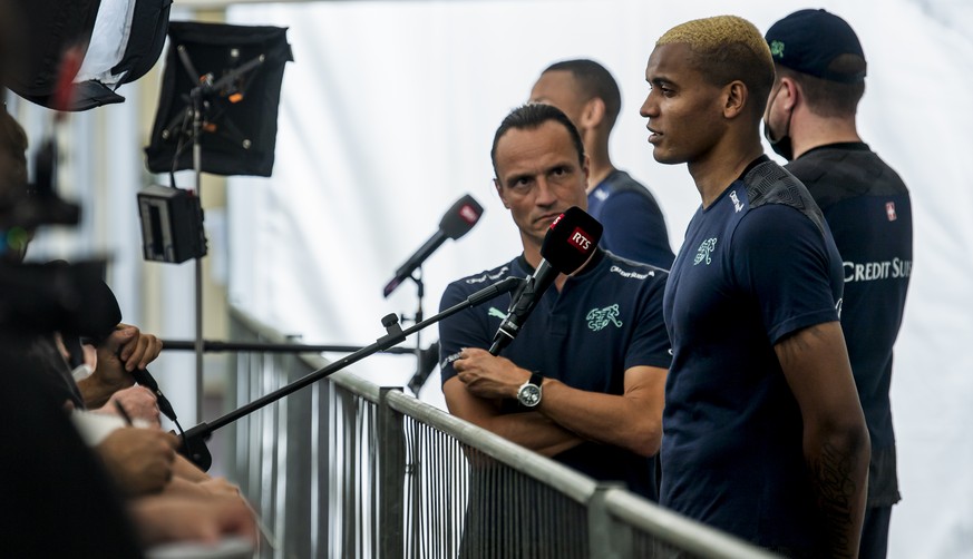 Switzerland&#039;s defender Manuel Akanji, speaks to journalists next to Adrian Arnold, left, head for the communication of the federation SFV during the Euro 2020 soccer tournament at the Tre Fontane ...
