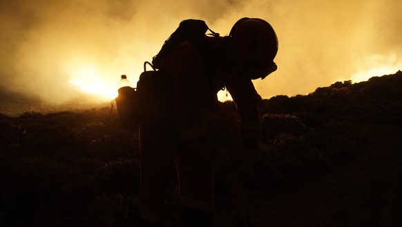 epa10811245 A handout photo made available by the Military Emergency Unit (UME) shows an UME member working to extinguish the forest fire in Arafo-Candelaria, Tenerife, Canary Islands, Spain, 21 Augus ...