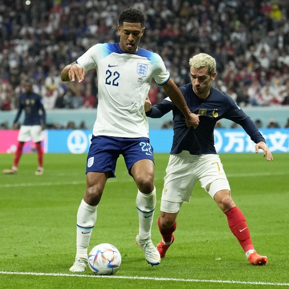 England&#039;s Jude Bellingham shields the ball from France&#039;s Antoine Griezmann, right, during the World Cup quarterfinal soccer match between England and France, at the Al Bayt Stadium in Al Kho ...