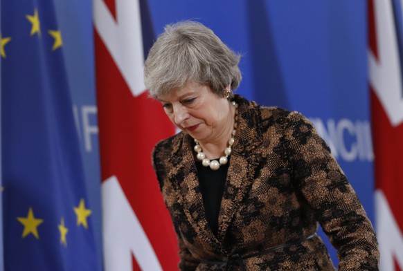 British Prime Minister Theresa May walks by the Union Flag and EU flag as she departs a media conference at an EU summit in Brussels, Friday, Dec. 14, 2018. European Union leaders expressed deep doubt ...