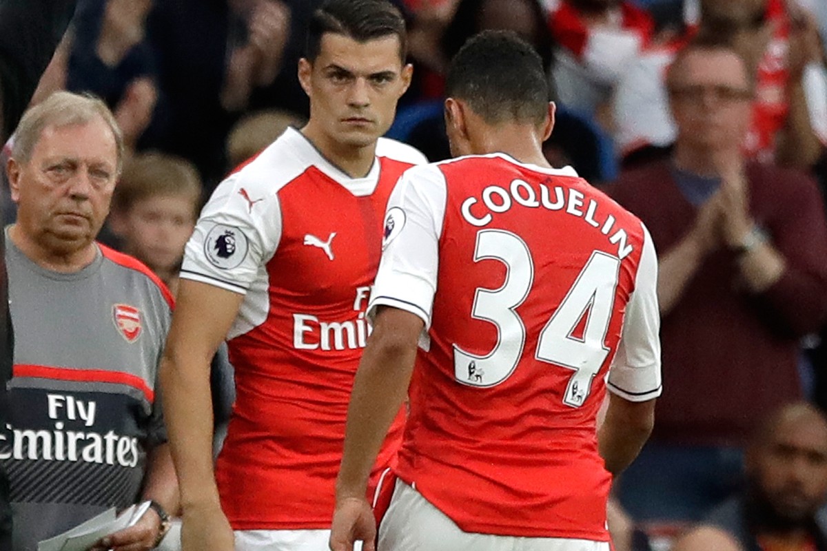 Arsenal's Granit Xhaka, center, replaces teammate Francis Coquelin, right, during the English Premier League soccer match between Arsenal and Chelsea at the Emirates Stadium in London, Saturday,  ...