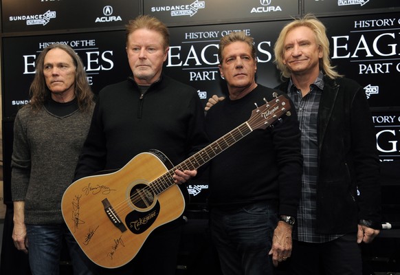 FILE - Members of The Eagles, from left to right: Timothy B. Schmit, Don Henley, Glenn Frey and Joe Walsh pose with a signed guitar after a press conference at the Sundance Film Festival, in Park City, Utah...