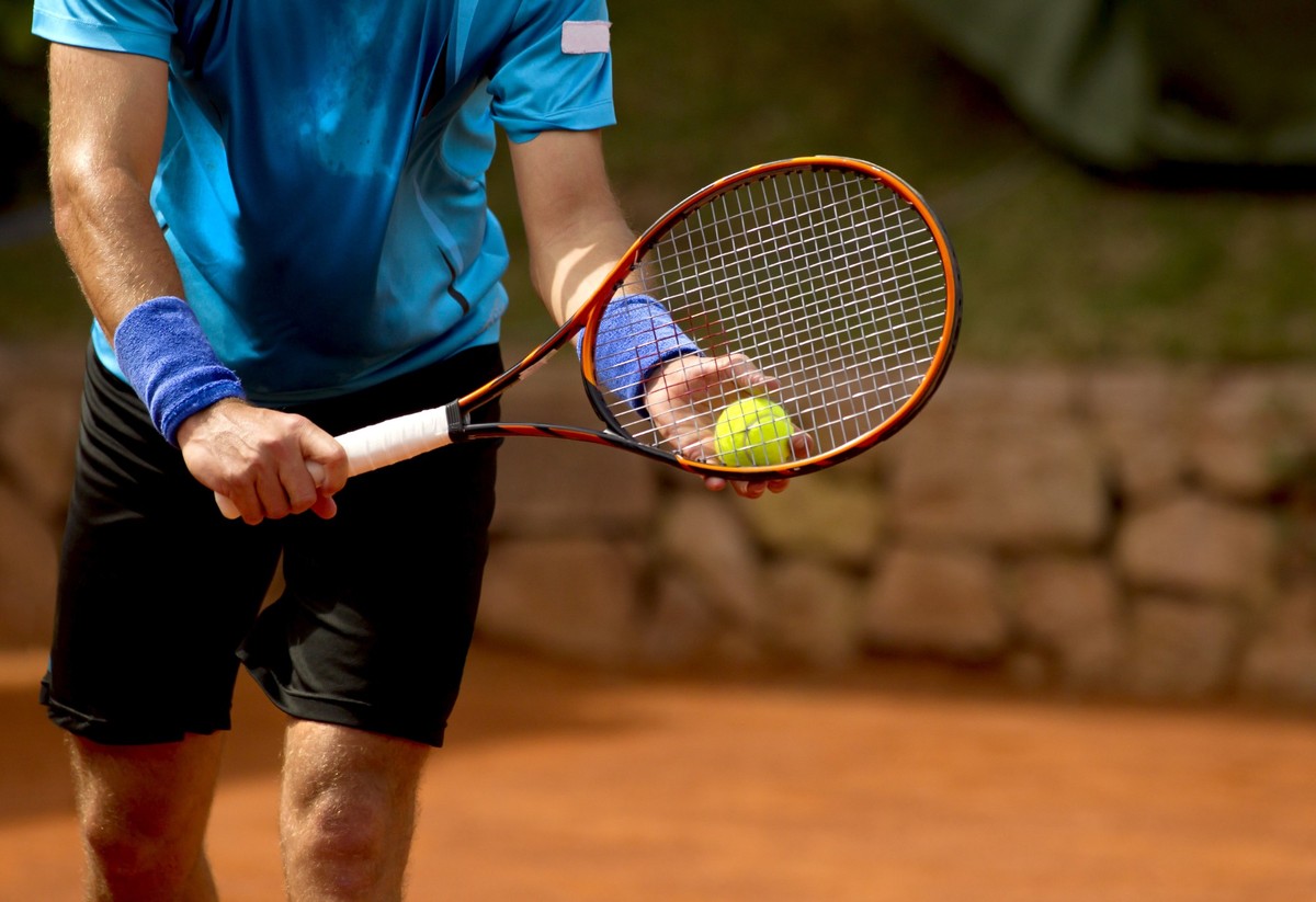 Ein Tennisspieler bereitet sich darauf vor, während eines Spiels einen Tennisball zu spielen