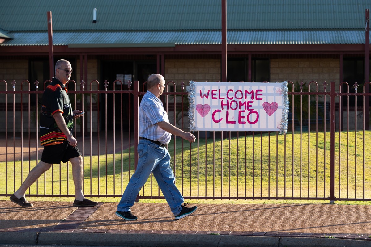 epa09566982 People walk pass a 'Welcome Home Cleo' sign placed in support of missing girl Cleo Smith (4) who was rescued by Western Australian Police on Wednesday morning in Carnarvon, 900km ...