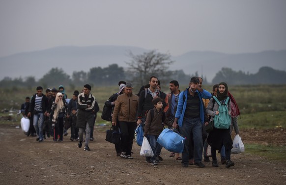 epa12347932 (FILE) - Migrants walk to the registration camp after they cross the border between Greece and Macedonia, near the city of Gevgelija, The Former Yugoslav Republic of Macedonia, 24 Septembe ...