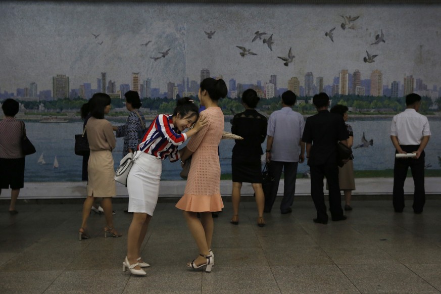 In this Thursday, Sept. 13, 2018, photo, North Koreans chat while waiting for a train in a subway station in Pyongyang, North Korea. (AP Photo/Kin Cheung)
