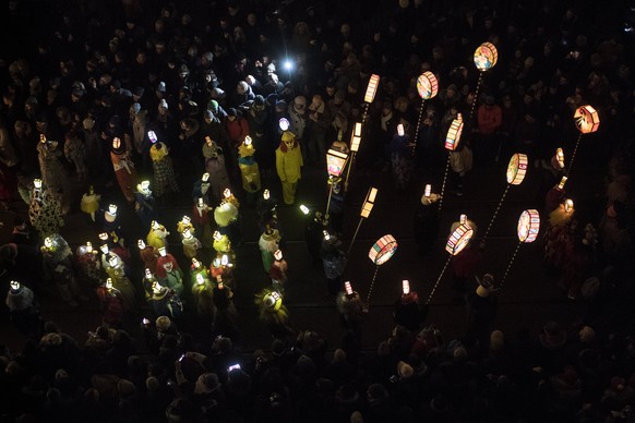 epa06541677 Revelers wearing masks and holding lanterns parade through the streets during the so-called &#039;Morgestraich&#039; in Basel, Switzerland, 19 February 2018. The traditional &#039;Morgestr ...