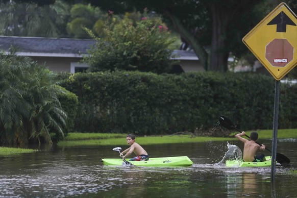 John Johnson, 8, left, and Joey Brooks, 12, play in their flooded neighborhood of Shore Acres in between passing thunderstorms during Tropical Storm Hermine in St. Petersburg, Fla., Thursday, Sept. 1, ...
