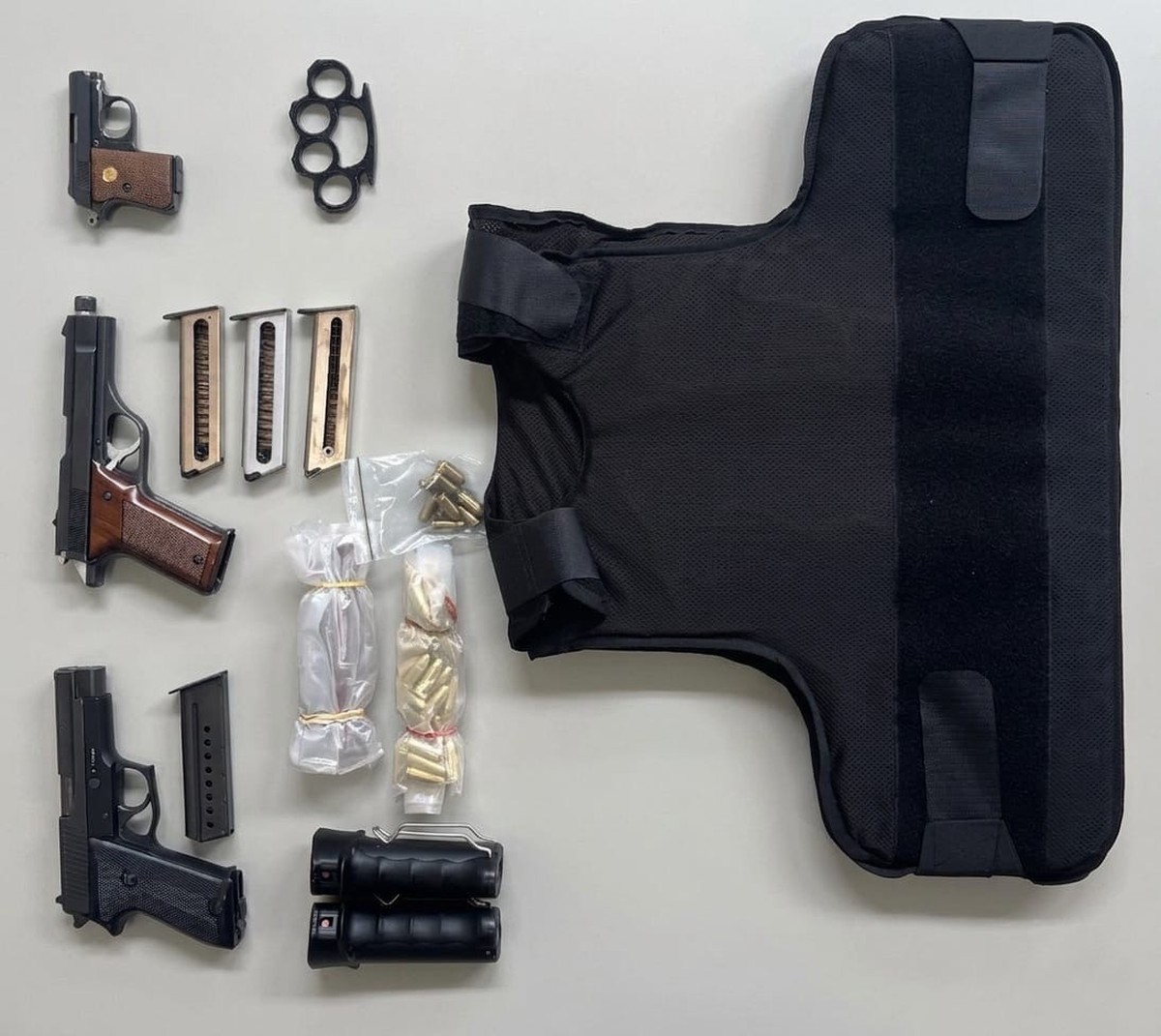 Schusswaffen, Munition und eine schusssichere Weste liegen auf einem Tisch Hanfanlage ausgehoben
