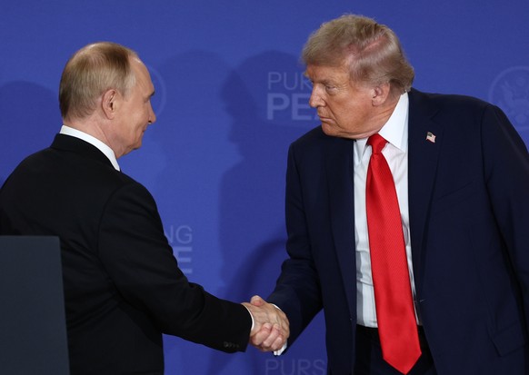 epaselect epa12303746 Russian President Vladimir Putin (L) and US President Donald Trump shake hands at the end of a joint news conference following their meeting at Joint Base Elmendorf-Richardson in ...