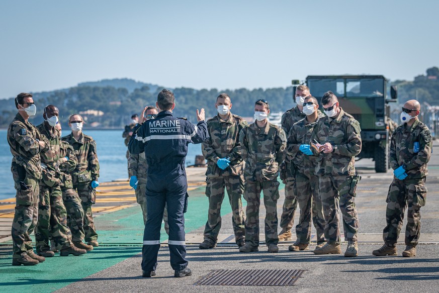 epa08367122 A handout photo made available by the French Defense Ministry on 16 April 2020 shows the briefing of a disinfection team of the French nuclear aircraft carrier Charles De Gaulle in Toulon, ...