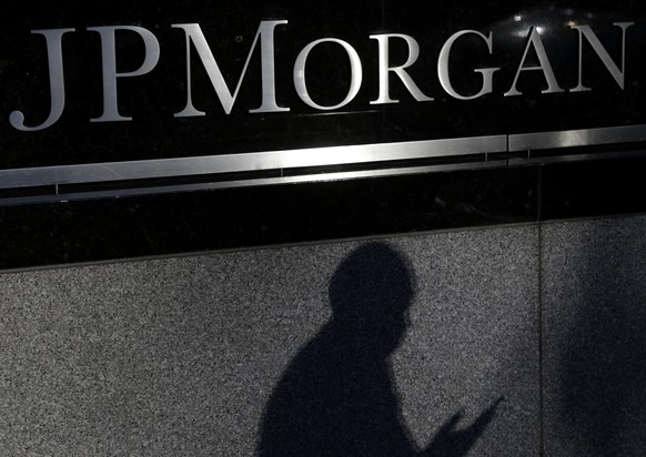 FILE - In this Nov. 19, 2013, file photo, the shadows of a pedestrian is cast under a sign in front of JPMorgan Chase &amp; Co. headquarters in New York. JPMorgan Chase on Monday, Nov. 3, 2014 said th ...