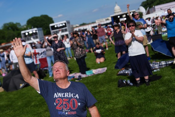 Teddy May, from Mobile, Alabama, kneels while worshiping during Rededicate 250, a mostly conservative Christian prayer gathering in honor of the United States' 250th anniversary, on the National  ...