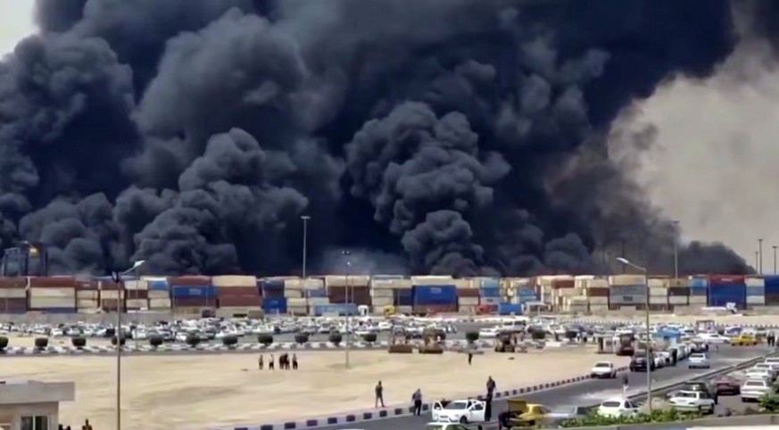 epa12056207 A video grab made available by the official website of Iranian state TV Islamic Republic of Iran Broadcasting (IRIB) shows smoke rising at Rajaie port, in city of Bandar Abbas, southern Ir ...