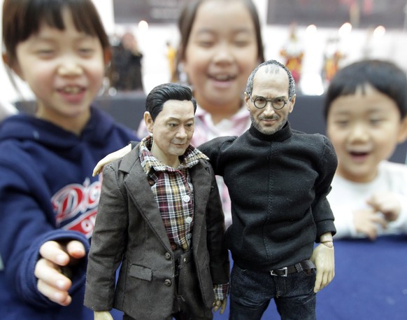 epa08771886 (FILE) - Children play with dolls depicting Samsung Electronics Chairman Lee Kun-hee (L) and the late Apple co-founder Steve Jobs (R) at the 2011 Seoul Doll Fair at a convention center in  ...