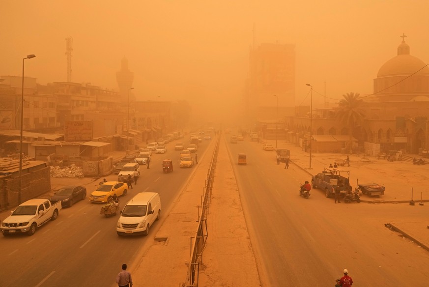 People navigate a street during a sandstorm in Baghdad, Iraq, Monday, May 16, 2022. (AP Photo/Hadi Mizban)