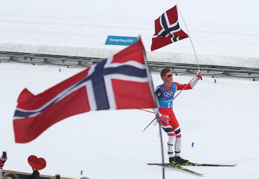 epa06538691 Johannes Hoesflot Klaebo of Norway celebrates as he crosses the finish line to win the gold the Men&#039;s Cross Country 4 x 10 km Relay race at the Alpensia Cross Country Centre during th ...