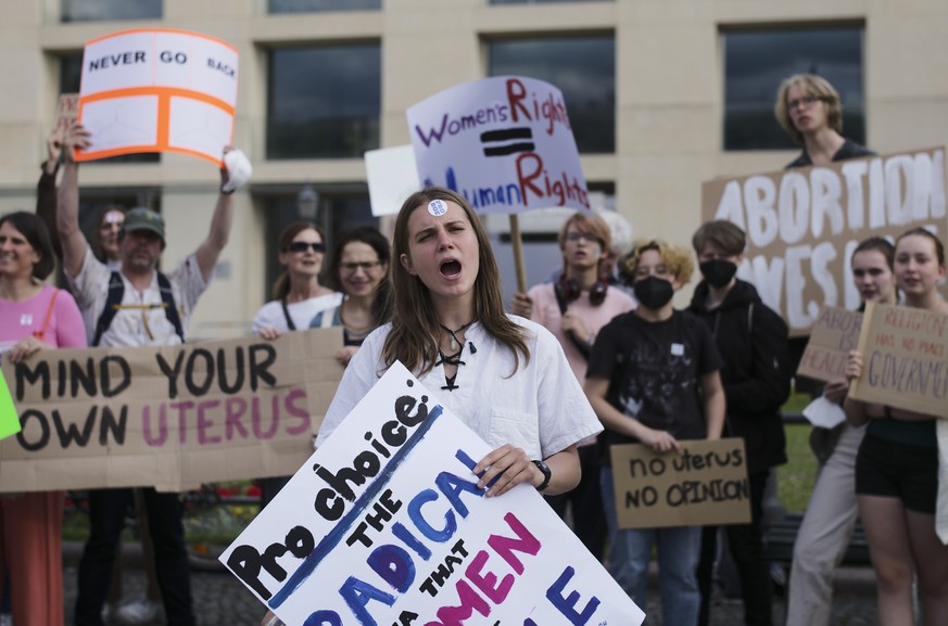 Protestors show posters as they attend a demonstration against the United States Supreme Court decision to overturn Roe v. Wade in front of the Brandenburg Gate near the US embassy in Berlin, Germany, ...