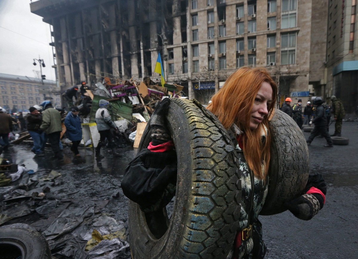 epa04499146 (FILE) A file picture made available 22 November 2014 shows a young Ukrainian woman carrying tires, helping to build a new barricade on Independence Square in Kiev, Ukraine, 20 February 20 ...