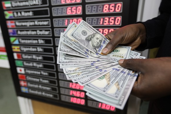 epa06949142 A Kenyan man shows one-hundred US dollar bills at a currency exchange office in Nairobi, Kenya, 14 August 2018. The Turkish currency Lira has lost some 40 percent in value against the US d ...