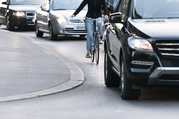 ARCHIV -- ZU DEN EIDGENOESSISCHEN ABSTIMMUNGEN VOM SONNTAG, 23. SEPTEMBER 2018, UEBER DIE VELO INITITAVE, STELLEN WIR IHNEN FOLGENDES BILDMATERIAL ZUR VERFUEGUNG -- A cyclist cycles among cars on Raem ...