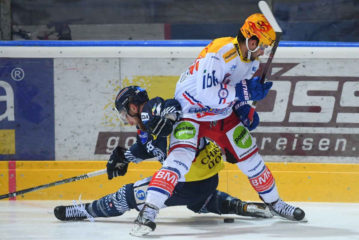 Ambri's player Jesse Zgraggen, left, fights for the puck with Kloten's player Vincent Praplan, right, during the preliminary round game of National League Swiss Championship 2017/18 between  ...