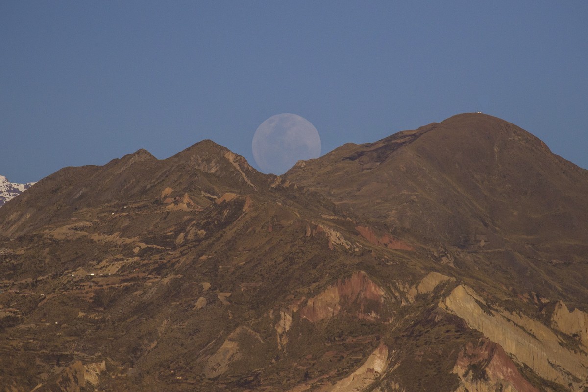 epa12228109 The full moon rises next to Mount Illimani in La Paz, Bolivia, 09 July 2025. EPA/Esteban Biba