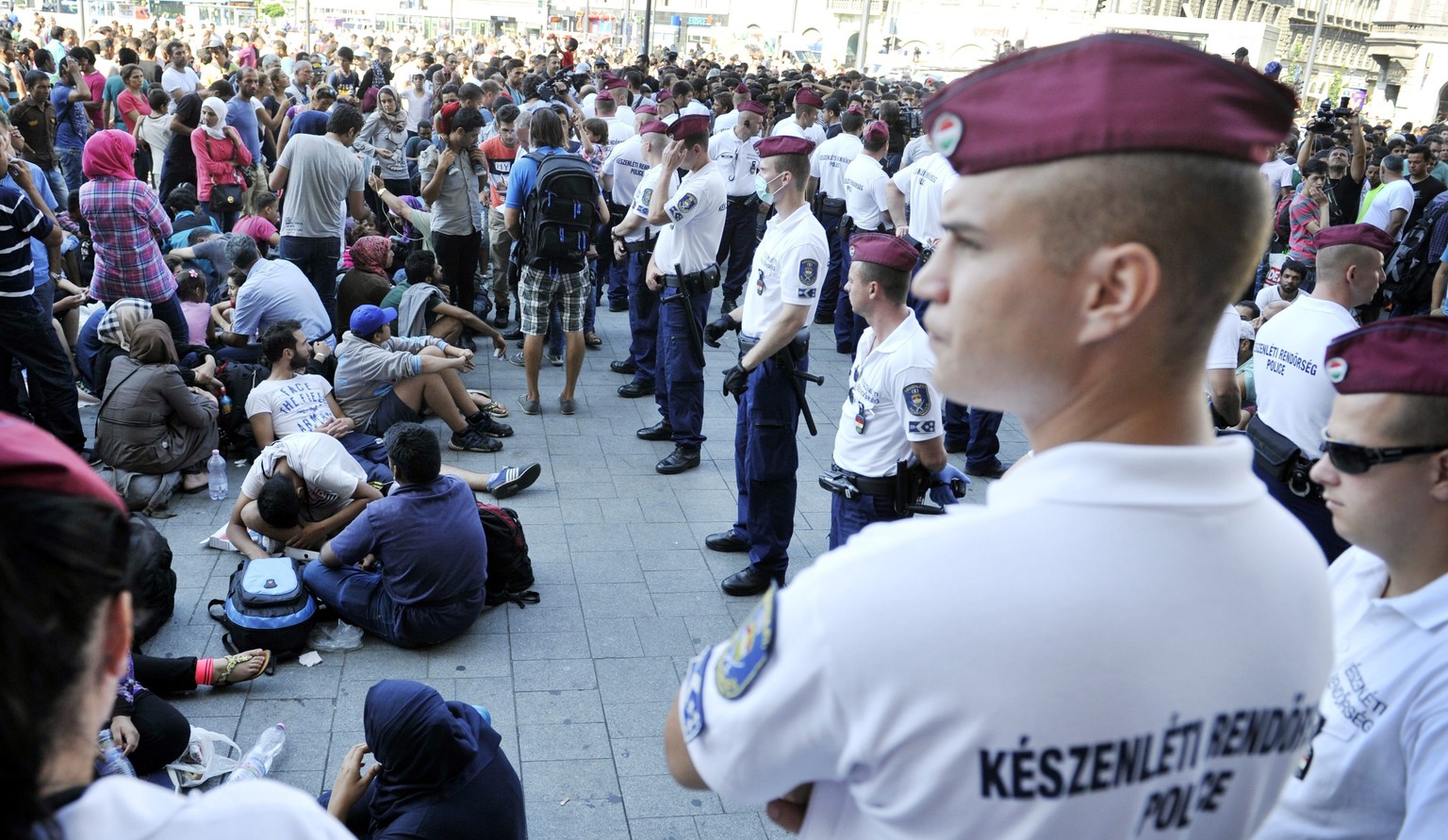 Migrants wait in front of the Keleti Railway Station in Budapest, Hungary, Tuesday, Sept. 1, 2015, after police stopped them from getting on a train to Germany and evacuated the station. (Tamas Kovacs ...