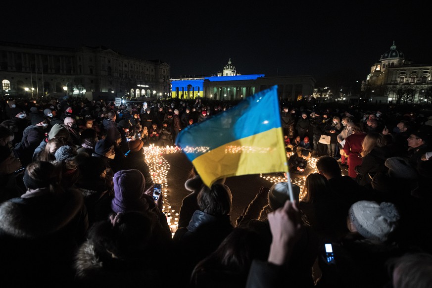 epa09790073 People attending a support vigil for Ukraine light candles to form a sea of lights during a demonstration against the Russian invasion of Ukraine at the Heldenplatz square in Vienna, Austr ...