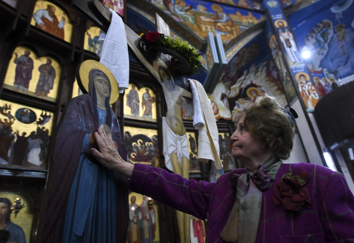 epa06649746 A woman touches the wooden statue of Jesus Christ on a cross at Skopje's main Orthodox Christian church St Kliment on Good Friday, Skopje, The Former Yugoslav Republic of Macedonia, 0 ...