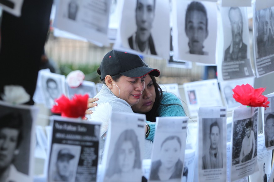 epaselect epa07804852 Women cry while looking at pictures of missing people during a demonstration in front of the National Palace, in Mexico City, Mexico, 30 August 2019. Relatives of missing people  ...