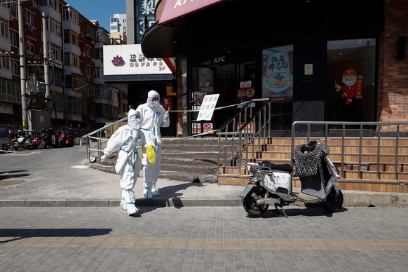 epa09917753 Health workers wearing protective suits walk along a road in the Chaoyang district in Beijing, China, 30 April 2022. Beijing authorities have announced the requirement of negative Covid-19 ...